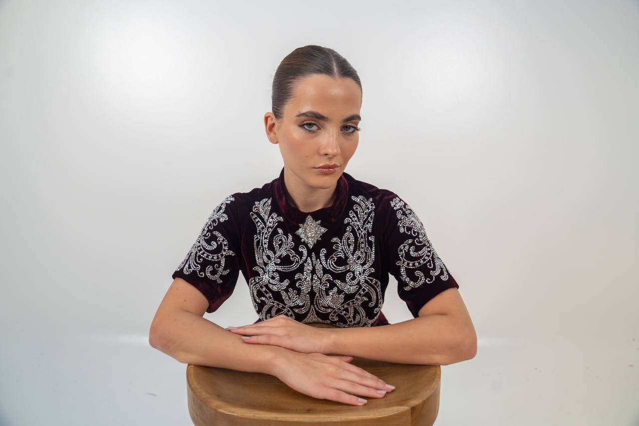 A distinctive burgundy velvet dress with hand embellishment. C:225