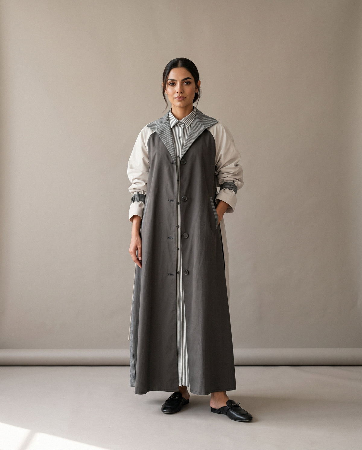 The Grey & Beige Trench Coat Abaya from the front: grey body, beige sleeves and grey striped details.