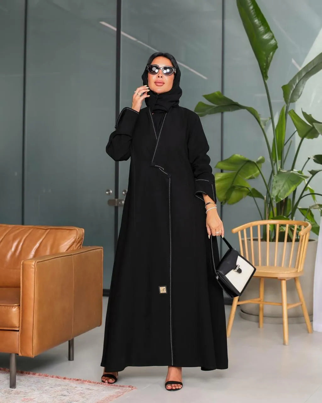 عباية من الكريب الأسود مع خياطة بيضاء وأزرار في الأمام