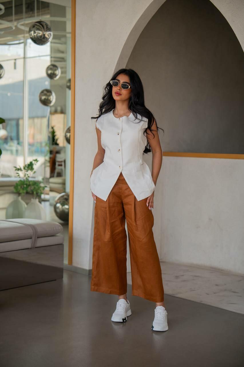 A practical set consisting of camel-colored pants with a white vest made of linen