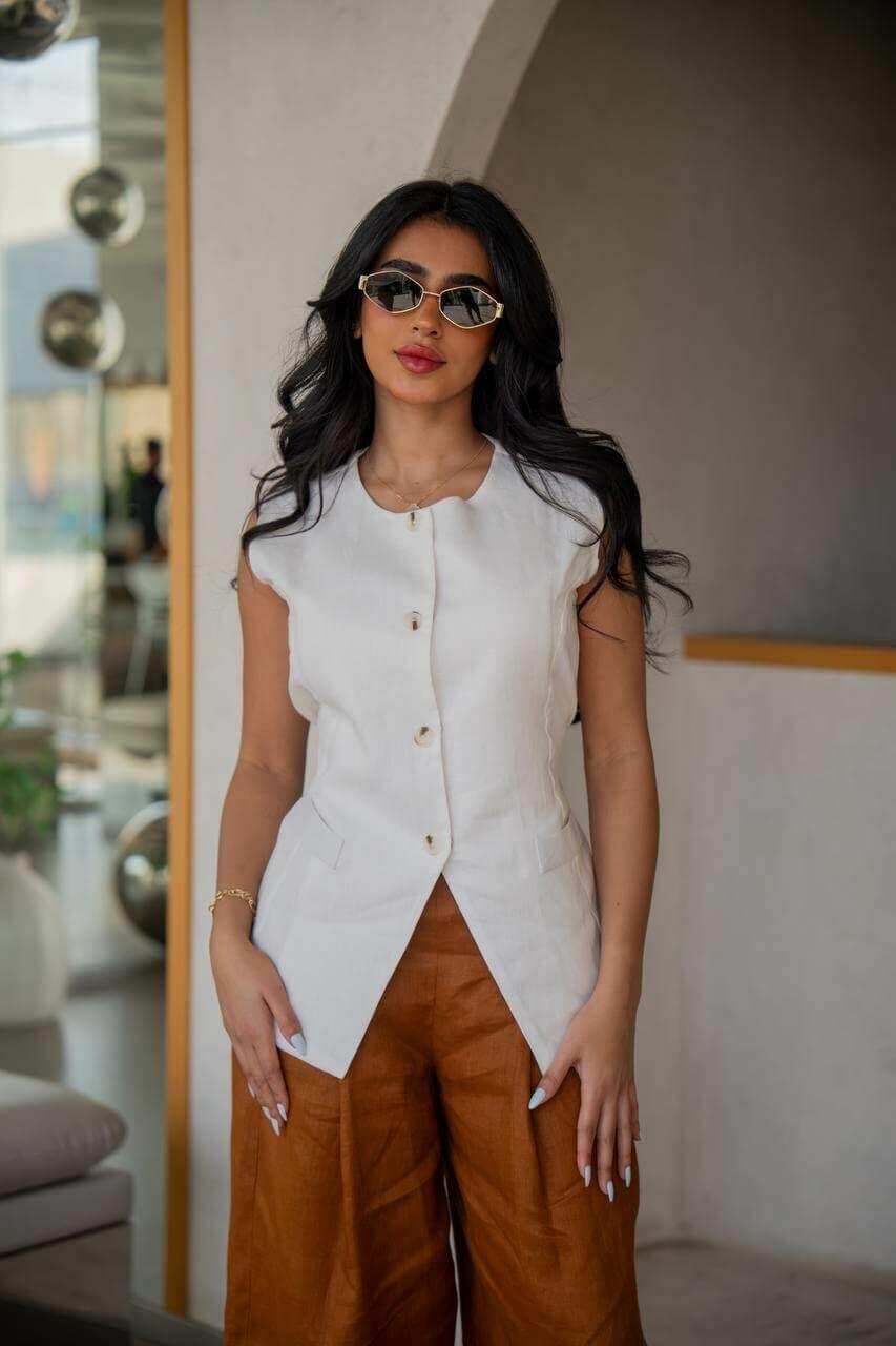 A practical set consisting of camel-colored pants with a white vest made of linen
