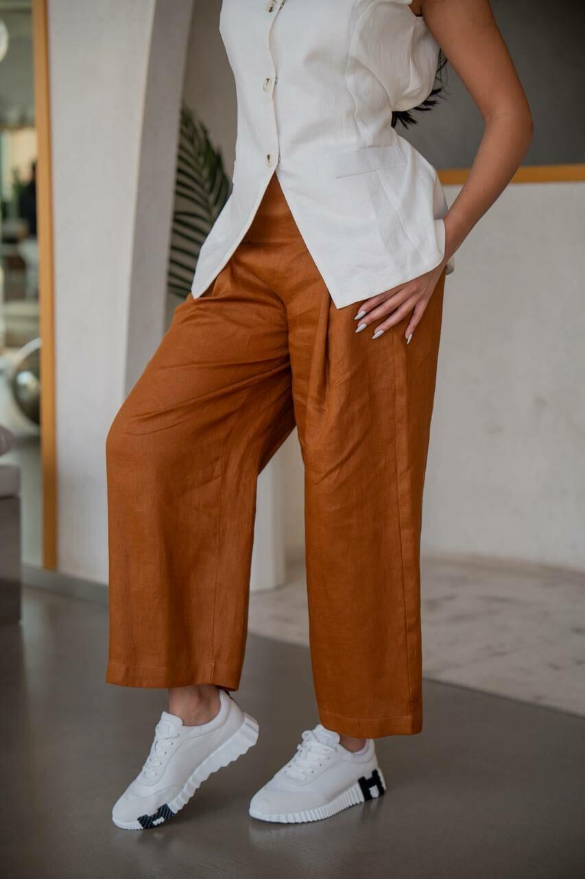 A practical set consisting of camel-colored pants with a white vest made of linen