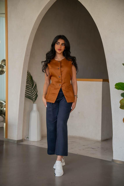 A practical  set consisting of navy blue pants with a camel-colored vest made of  linen.