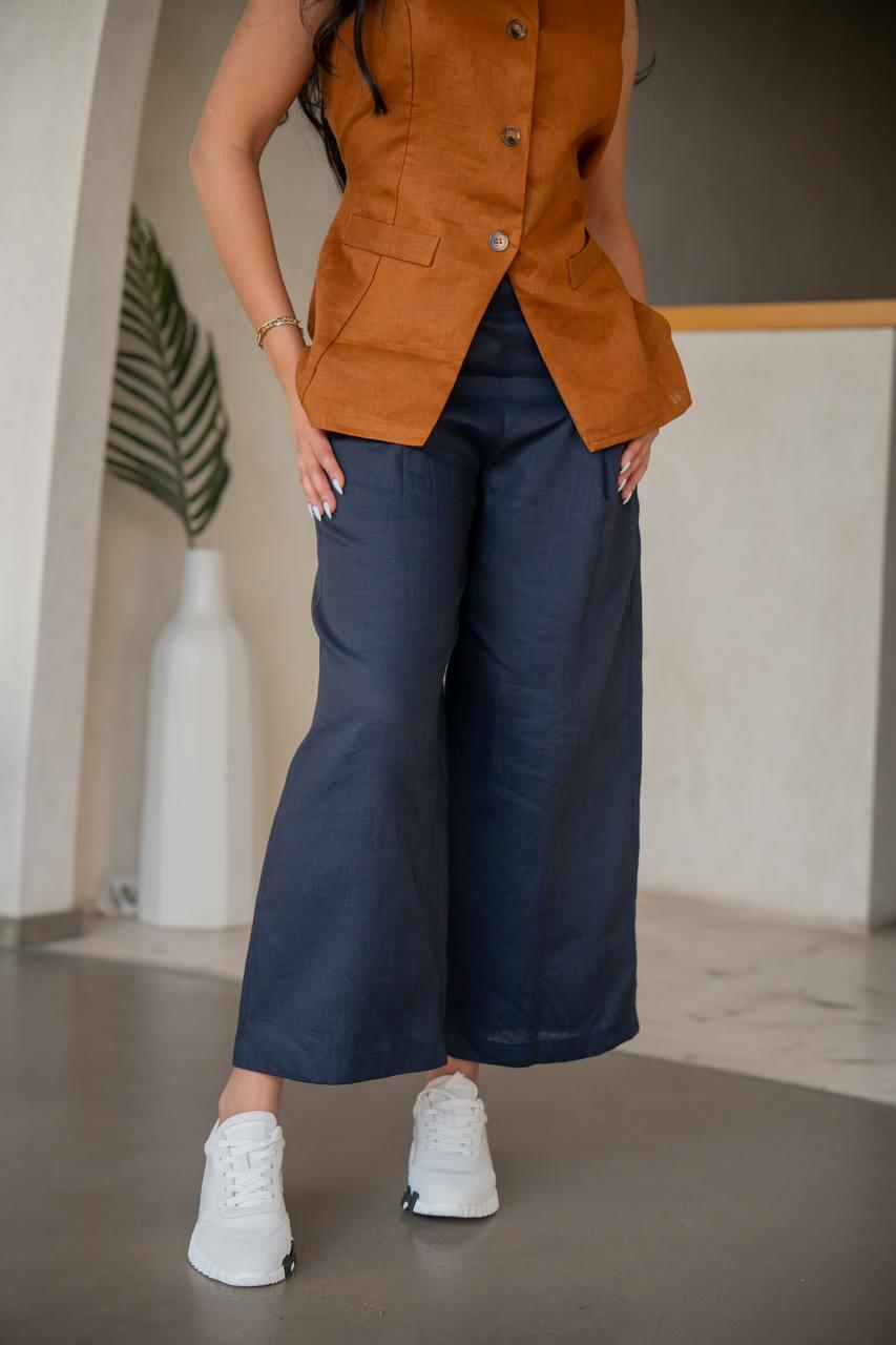 A practical  set consisting of navy blue pants with a camel-colored vest made of  linen.