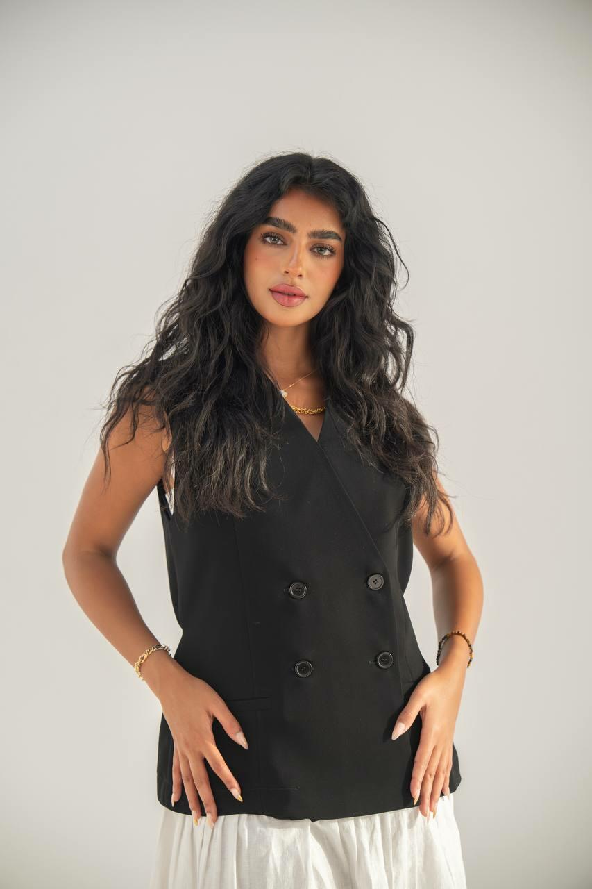 set consisting of a black crepe vest with a white linen skirt