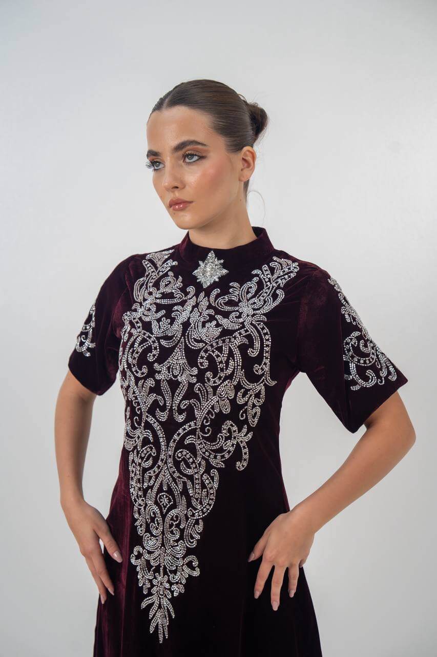 A distinctive burgundy velvet dress with hand embellishmen